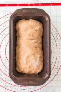 A shaped loaf of bread dough in a loaf pan - Hostess At Heart