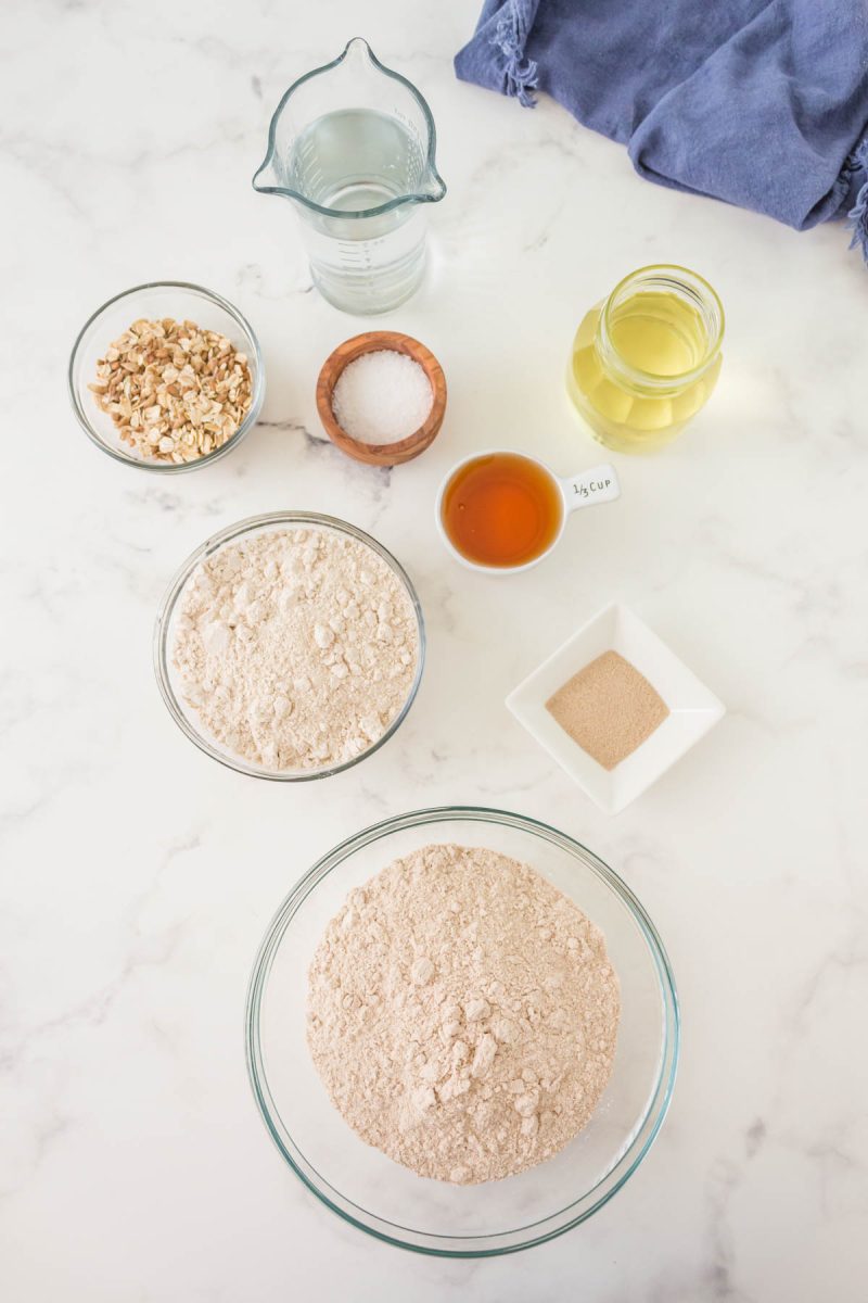 Top-down view of Organic Bread Ingredients including flour, yeast, honey, salt, oil, and water.