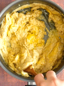 Egg added to a pan of Jewish Popover batter - Hostess At Heart