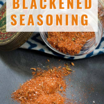 Titled image for blackened seasoning reciope for Pinterest of a glass jar tipped on it's side allowing the spices to spill out. Hostess At Heart