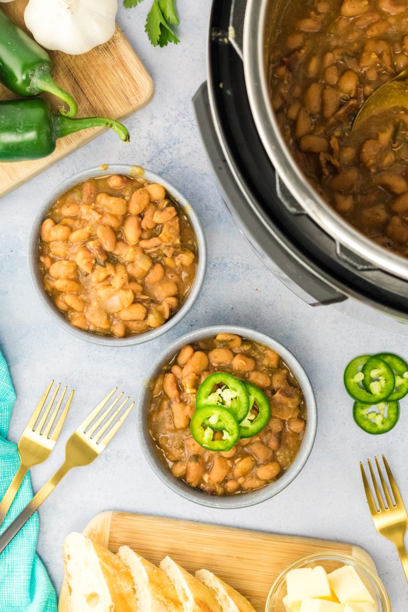 Top down view of bowls of charra beans topped with jalapeno pepper slices - Hostess At Heart
