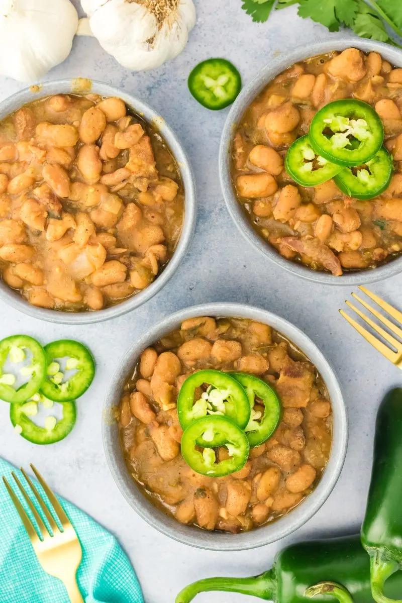 Top down view of a bowl filled with charros beans topped with jalapeno slices