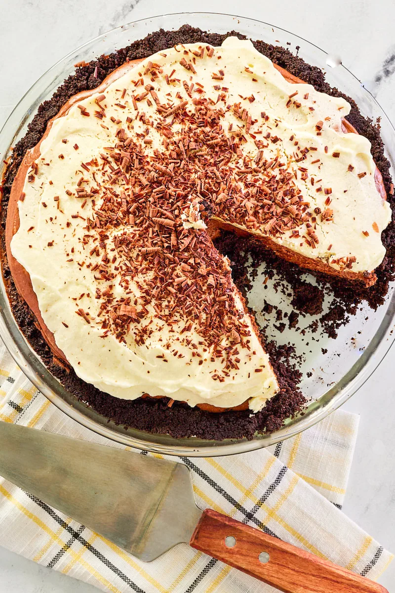 Top down view of a pie topped with whipped cream and chocolate shavings in a chocolate graham cracker crust - Hostess At Heart