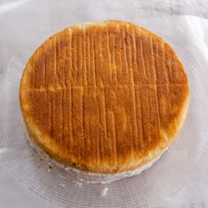 A second layer of a round cake added to the frosted 1st layer. - Hostess At Heart