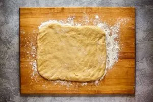Bread dough shaped into a rectangle on a bread board. Hostess At Heart