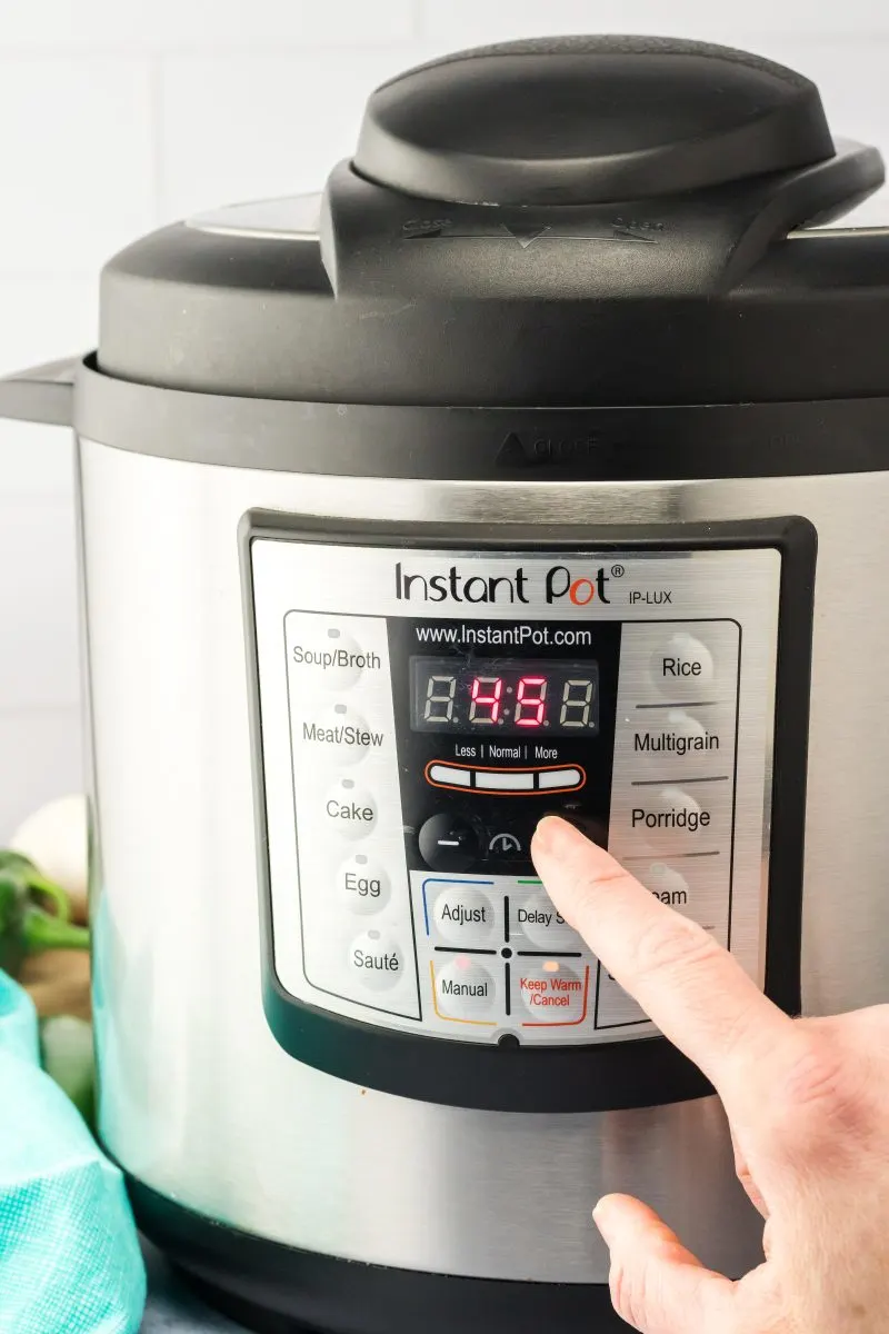 A finger pointing at the proper setting on an instant pot - Hostess At Heart