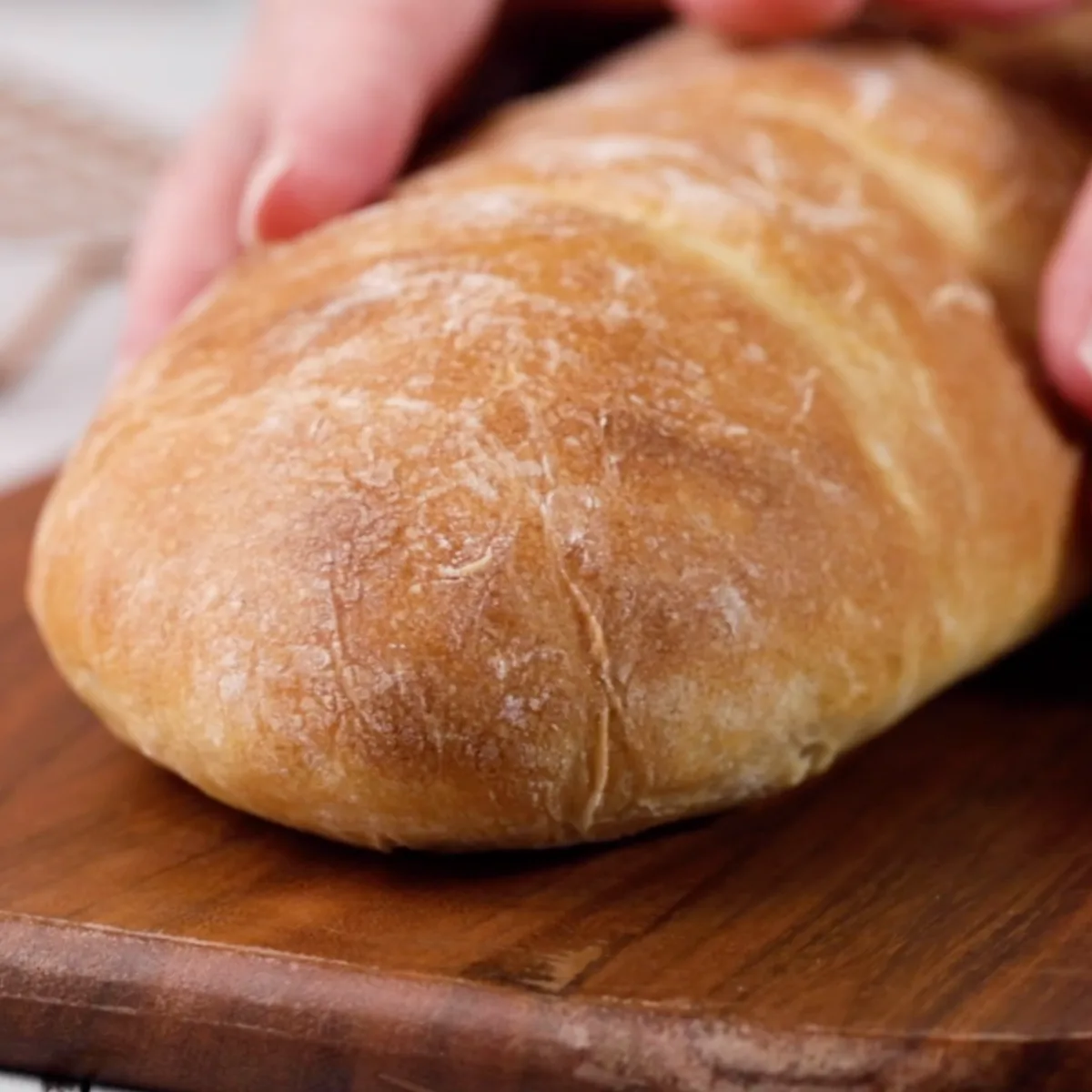 Front view of a baked loaf of Italian Bread sitting on a cutting board - Hostess At Heart