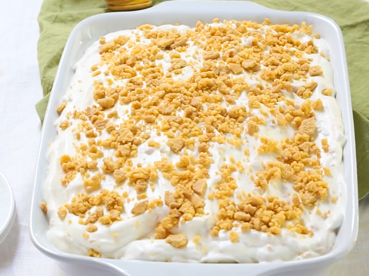Front view of a baking dish topped with whipped topping and crushed cookies - Hostess At Heart