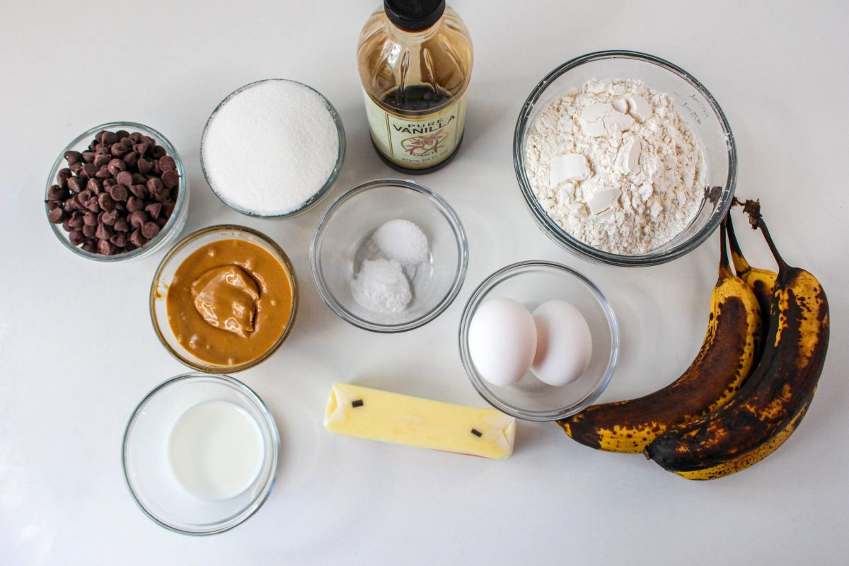 Ingredients used to make peanutbutter banana muffins including bananas, butter, peanut butter, sugar, salt, flour, vanilla extract, chocolate chips, eggs and baking soda - Hostess At Heart