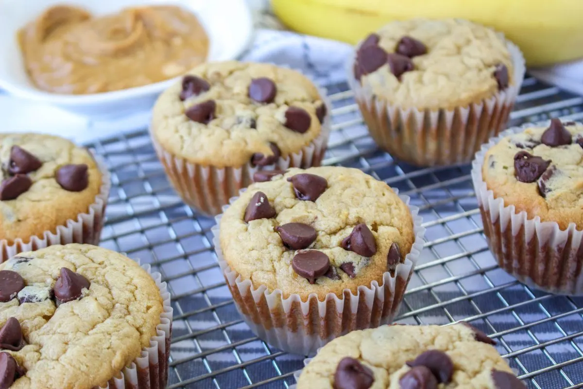Side angle of baked peanut butter banana muffins with chocolate chips - Hostess At Heart
