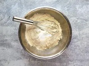 A bowl filled with the dry ingredients for a classic white cake recipie. Hostess At Heart