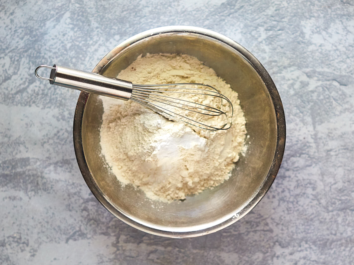 A bowl filled with the dry ingredients for a classic white cake recipie. Hostess At Heart