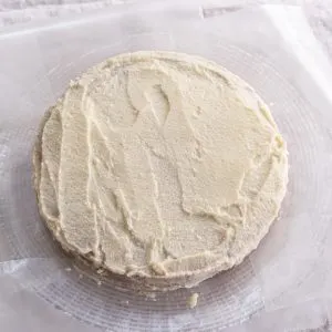 Top-down view of a cake covered with a scratch coating of white frosting