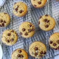 Top Down view of a cooling rack filled with Peanut Butter Banana Muffins topped with chocolate chips - Hostess At Heart