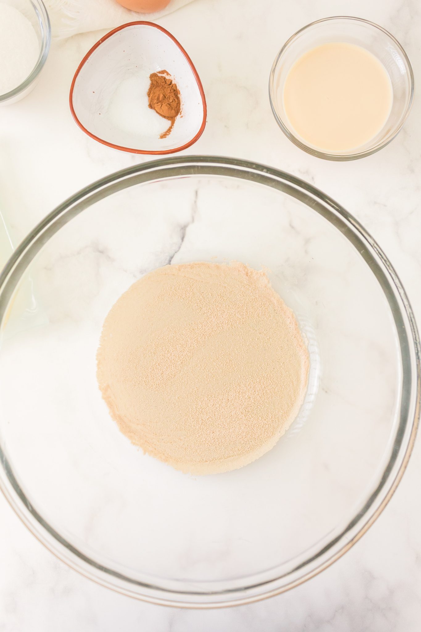 Sugar, water, and yeast in a glass bowl intended to bloom yeast - Hostess At Heart