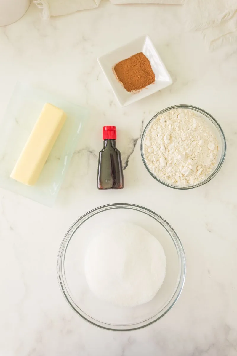 Top down view of the ingredients used to make concha topping including cinnamon, sugar, vanilla, butter, and flour.