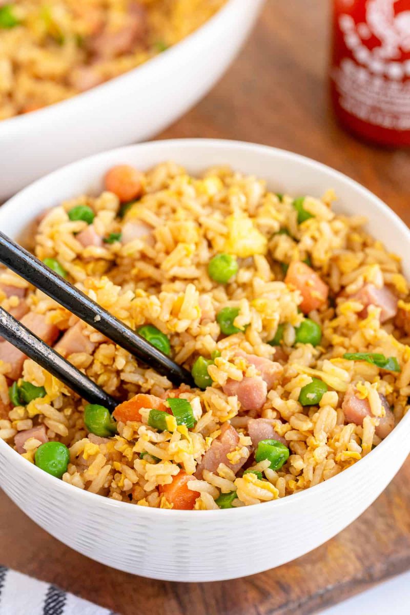 Bowl of fried rice mixed with chopped vegetables and ham.
