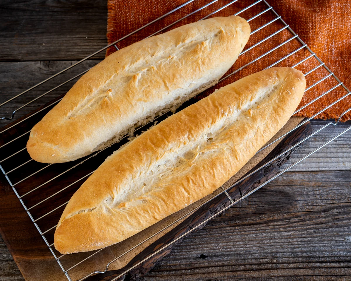 Two loaves of baked bread sitting on a cooling rack - Hostess At Heart