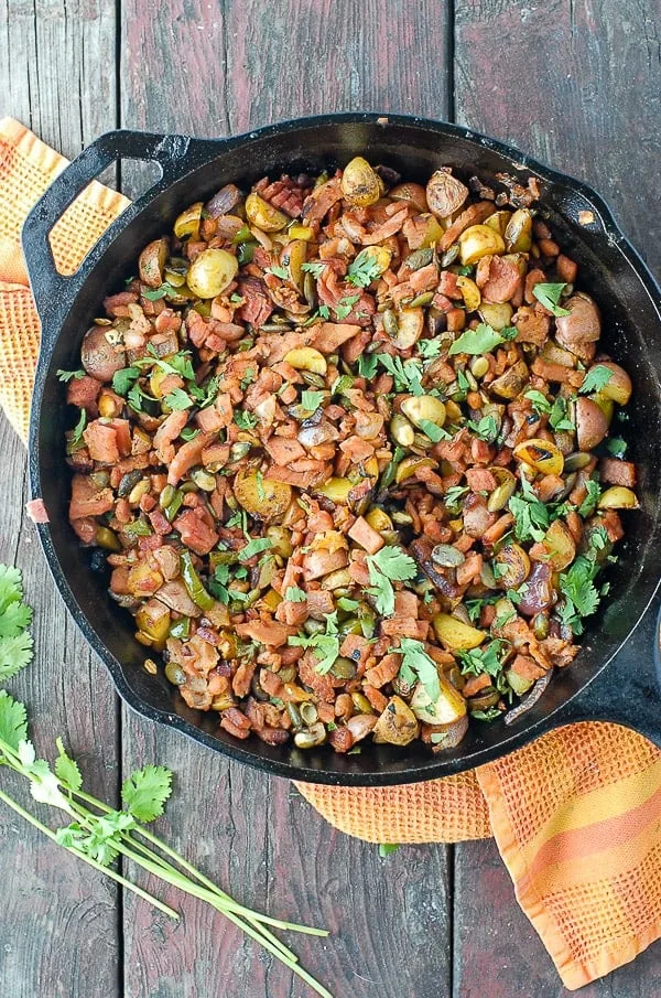 Top-down view of a cast iron skillet holding diced ham and potatoes