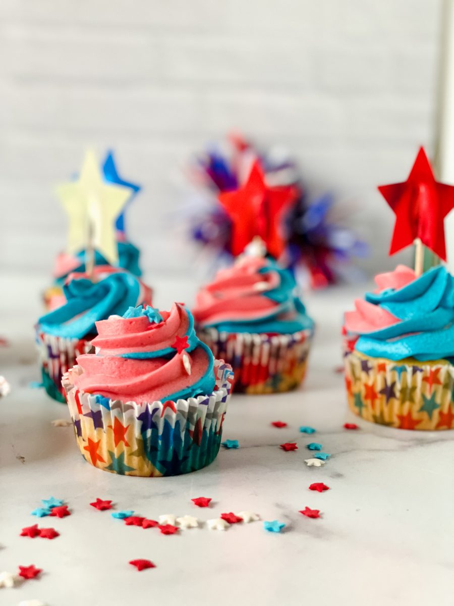 Sideview of cupcakes with red, white and blue swirled frosting and American Flag decorations - Hostess At Heart