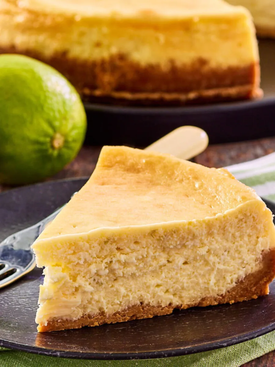 Sideview of a slice of cheese cake with a graham cracker crust - Hostess At Heart