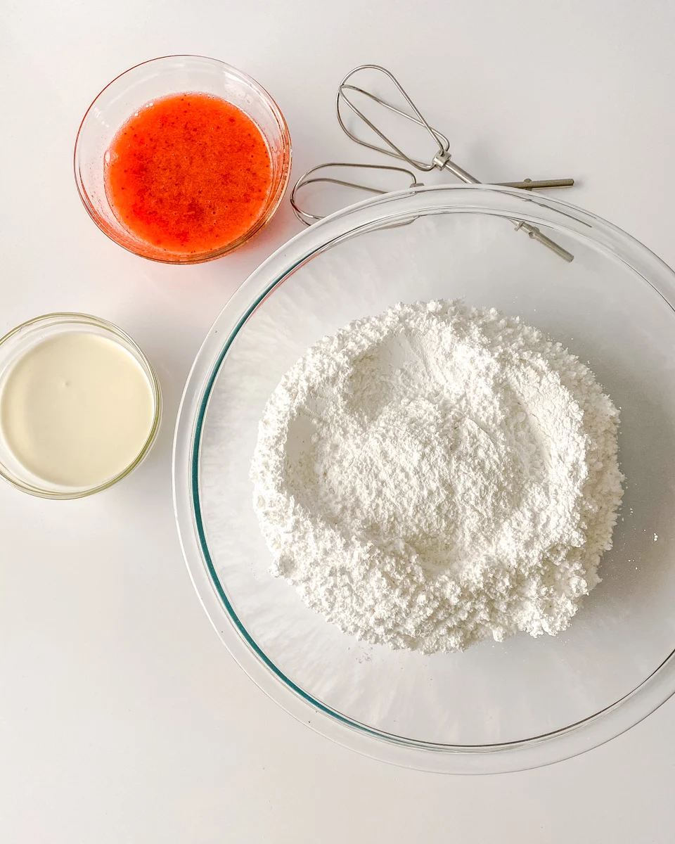 Ingredients used to make strawberry buttercream frosting including cream, powdered sugar, and strawberry puree - Hostess At Heart