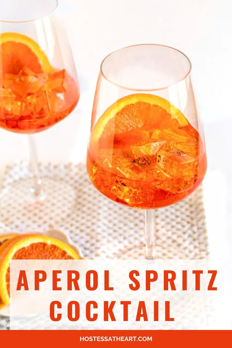 Front-view image for Pinterest of an Aperol Spritz cocktail with the title running across the bottom of the image. Hostess At Heart