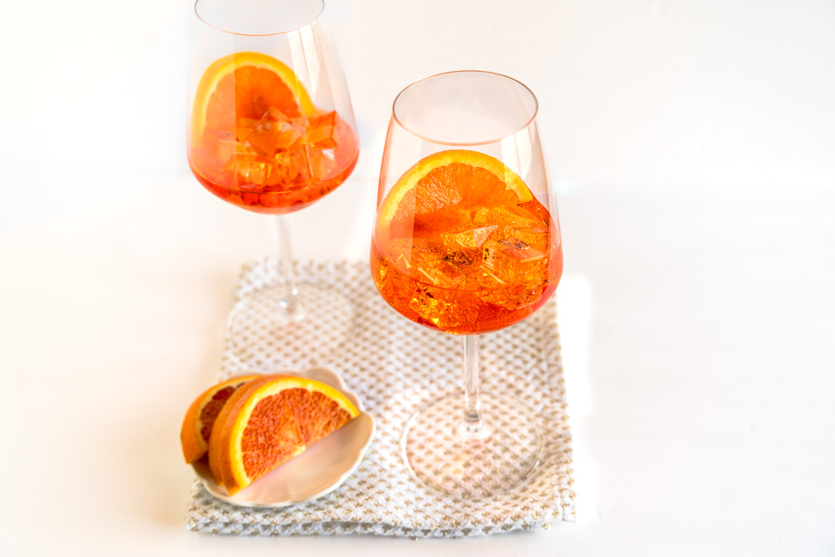Front view of two glasses filled with Ice and an Italian Cocktail called a Spritz - Hostess At Heart