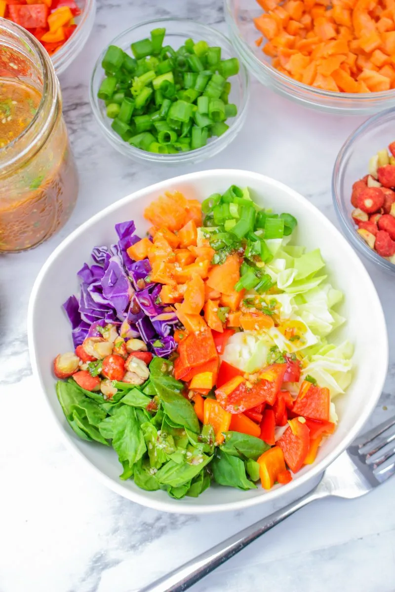 Top-down view of a bowl of chopped salad drizzled with dressing - Hostess At Heart