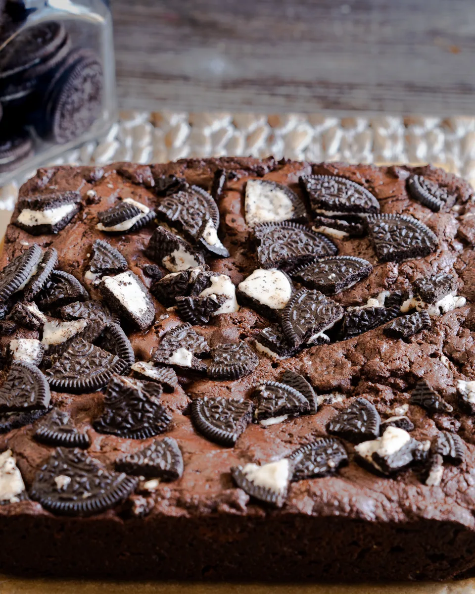 A pan of Fudgy Chocolate Oreo Brownies topped with chopped Oreos - Hostess At Heart