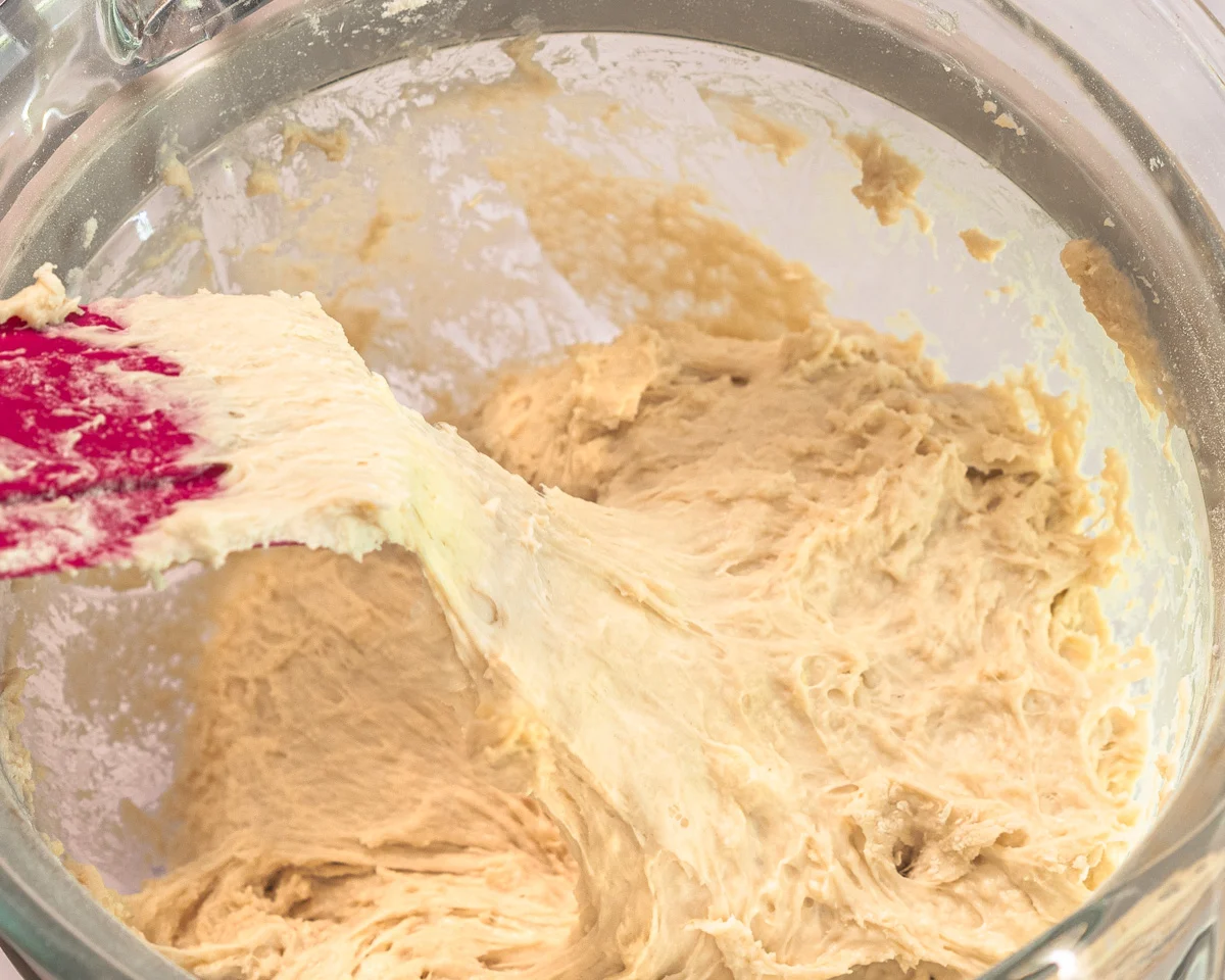 A spatula pulling bread dough showing it's sticky consistency - Hostess At Heart