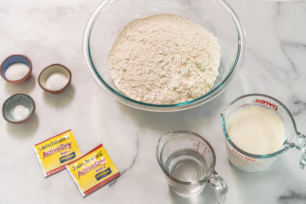 Ingredients used to make English Muffin Bred including flour, yeast, milk, water, salt, baking soda, and sugar.