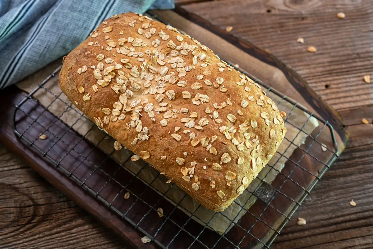 Top down view of a loaf of homemade English Muffin Bread topped with Oats - Hostess At Heart