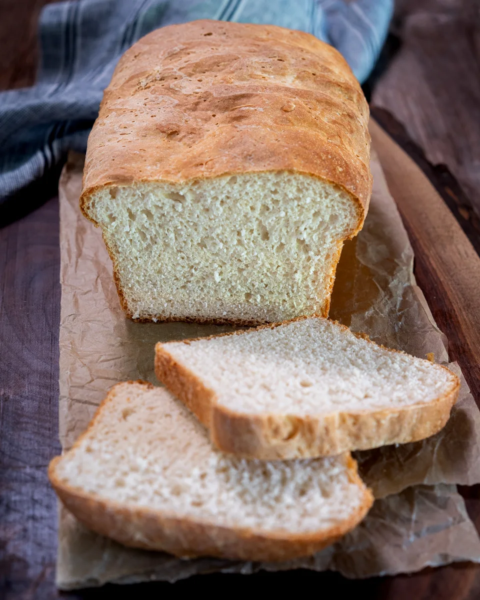 Front view of a sliced of loaf of bread with the first two slices laying in front of the loaf - Hostess At Heart