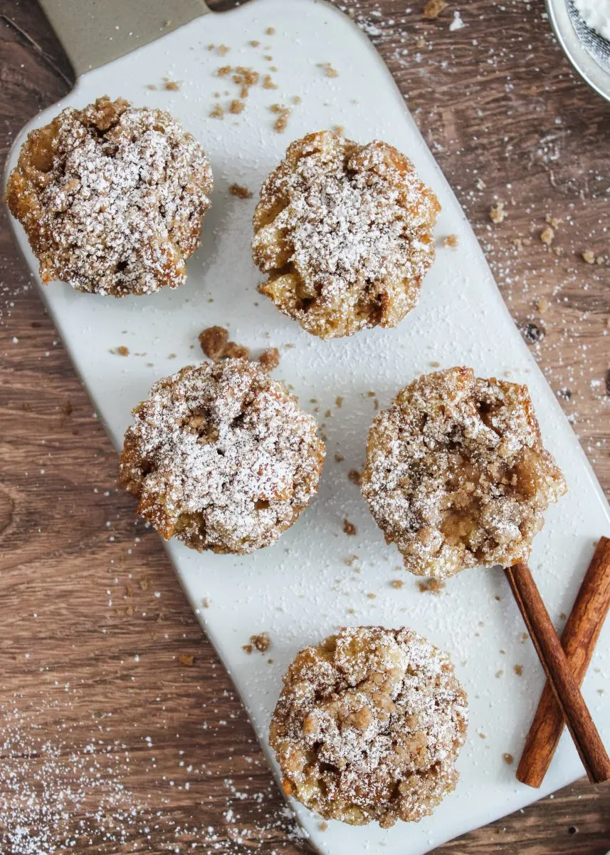 Top down view of French Toast Muffins dusted with powdered sugar on a white cutting board - Hostess At Heart