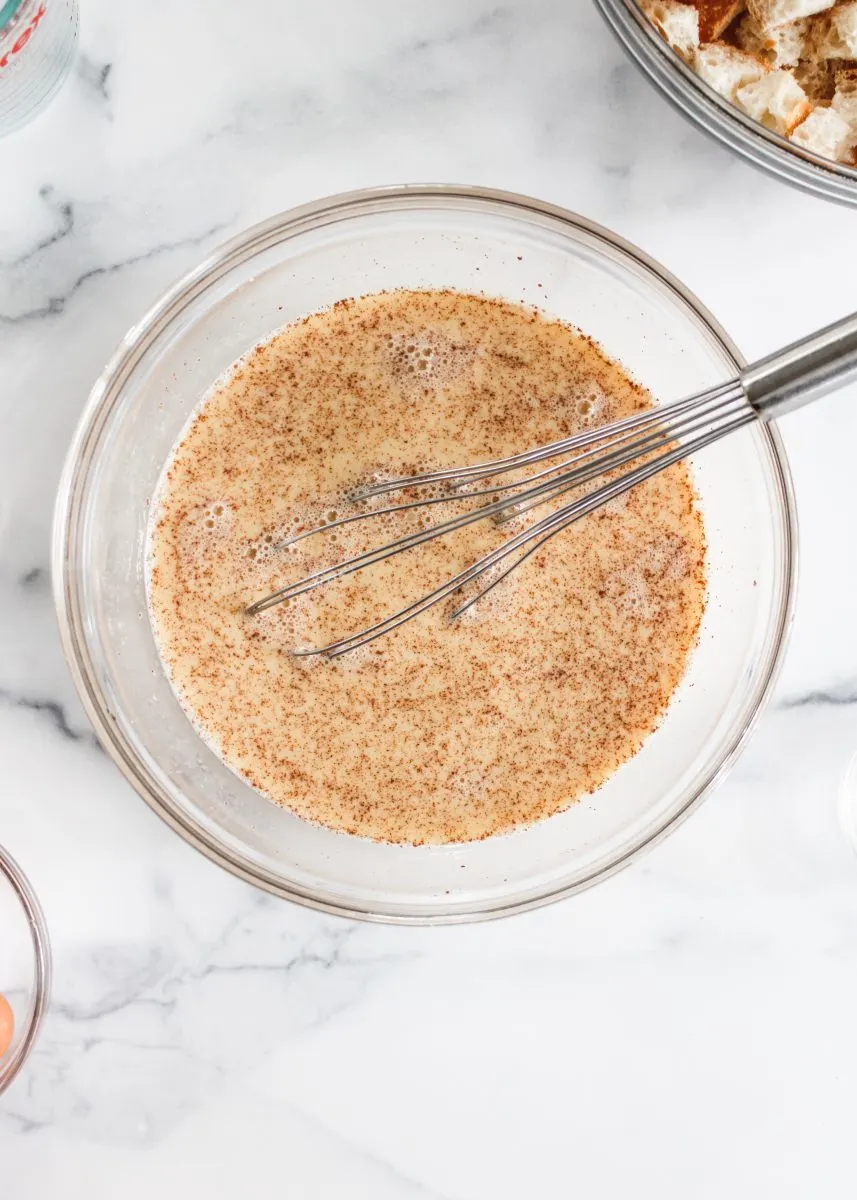 Top down view of a bowl filled with an egg mixture and ground cinnamon - Hostess At Heart