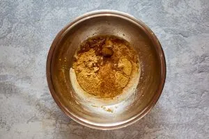 Mixing bowl filled with graham cracker crumbs, melted butter, and brown sugar - Hostess At Heart