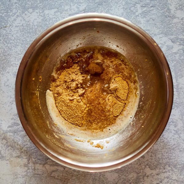 Mixing bowl filled with graham cracker crumbs, melted butter, and brown sugar - Hostess At Heart