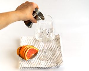 Front view of Prosecco being added to a glass of ice in order to make a aparol spritz - Hostess At Heart