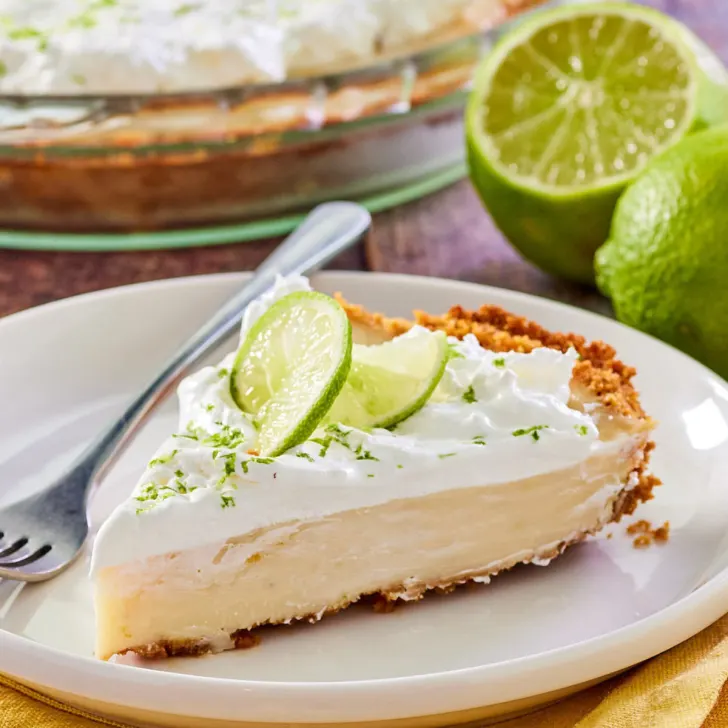 A side angle of a slice of a Key Lime Pie with a graham cracker crust - Hostess At Heart