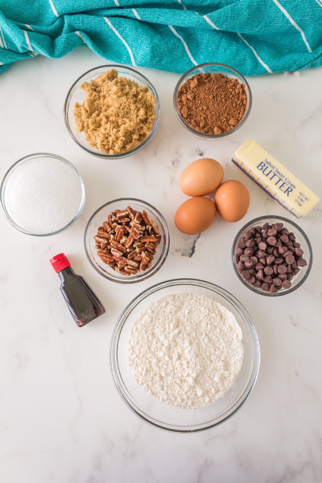Side view close up of a piece of pecan-filled chocolate turtle brownies sitting on a spatula. Hostess At Heart