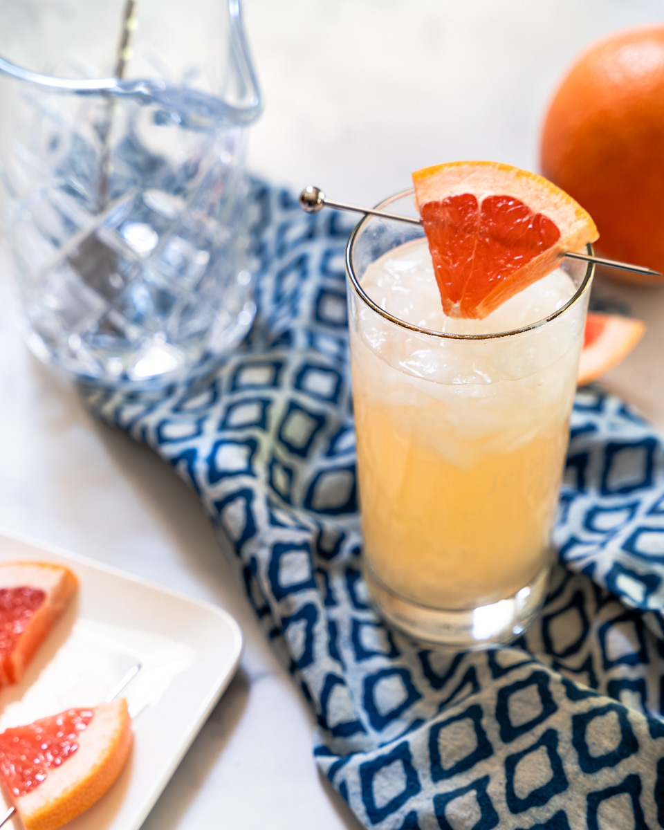 Sideview of a chilled alcohol drink garnished with grapefruit - Hostess At Heart