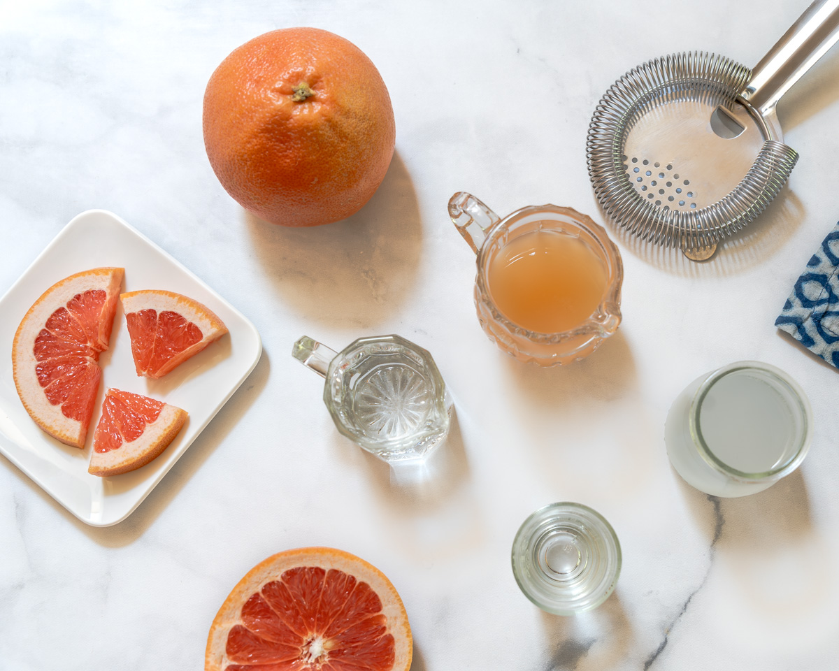 Ingredients used in a Grapefruit Crush Cocktail including fresh grapefruit juice, lemon-lime soda, triple sec, vodka and a grapefruit garnish. - Hostess At Heart