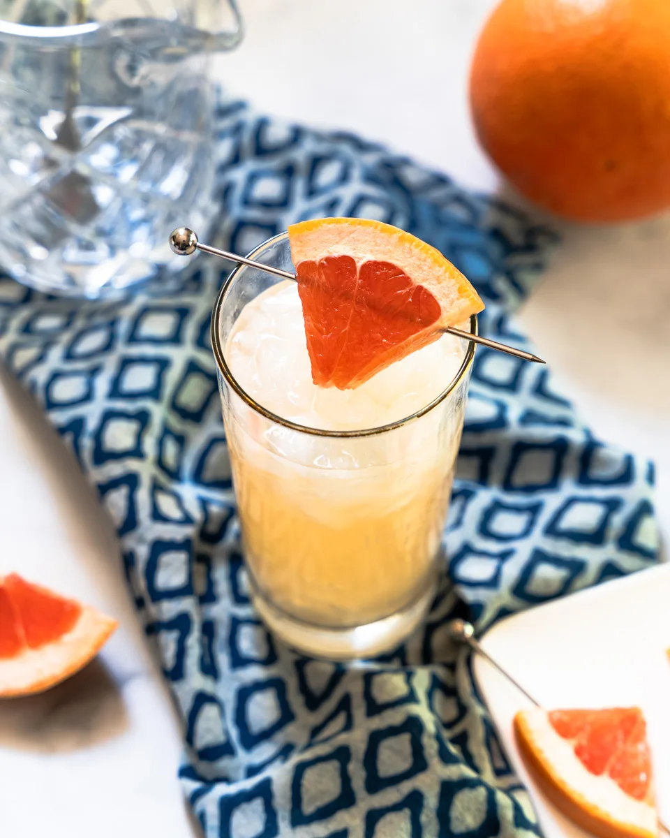 Top-down view of a cocktail garnished with a wedge of fresh grapefruit - Hostess At Heart