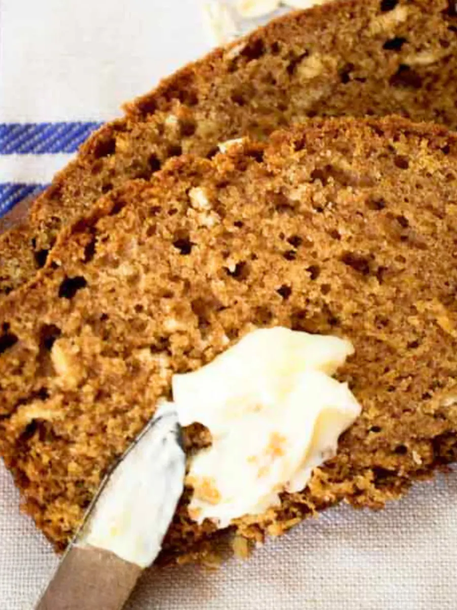 Closeup of slices of Apple sauce Oatmeal Bread dotted with butter.