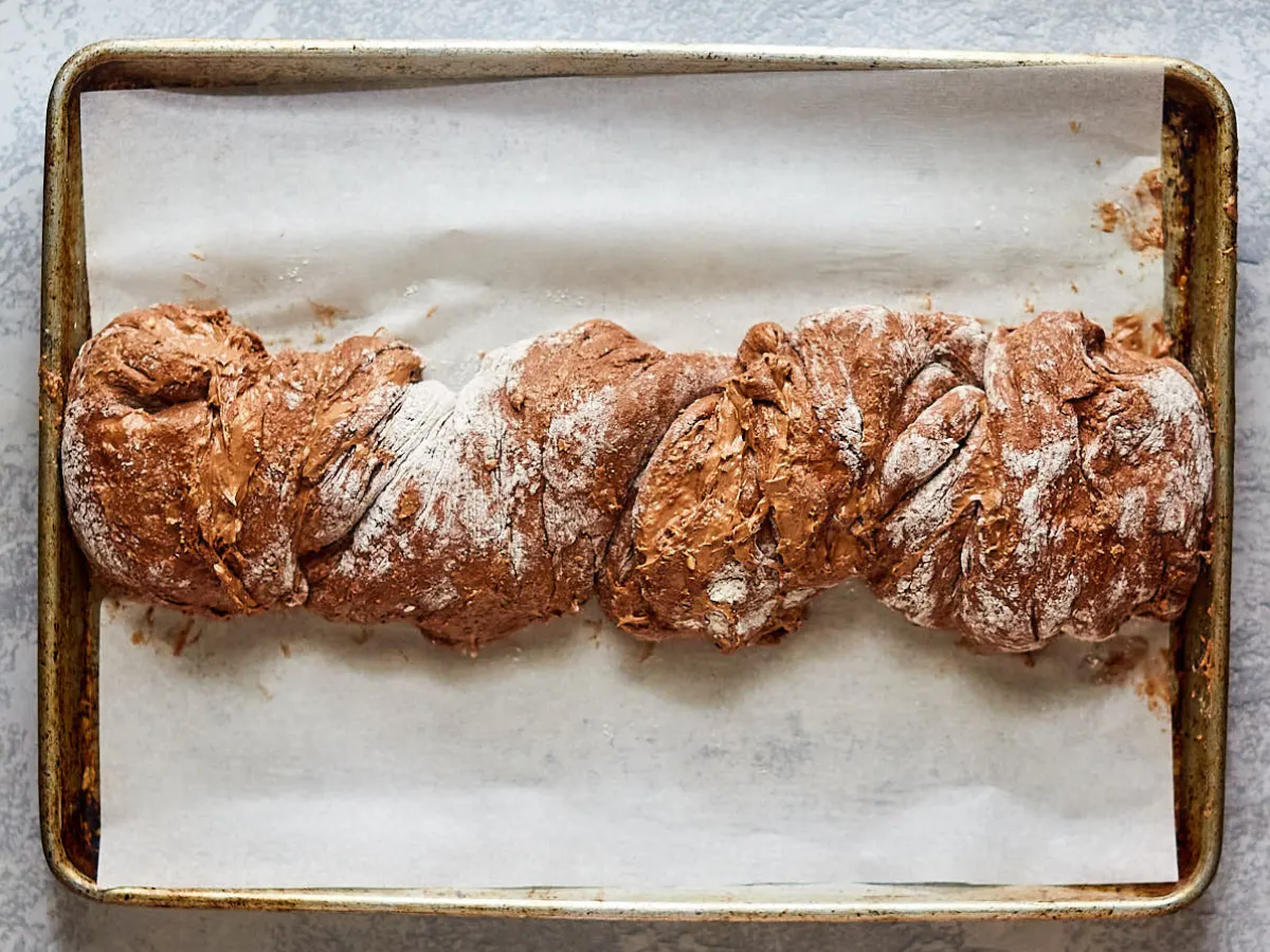 Chocolate Babka Bread dough twisted and placed on a parchment paper-lined baking sheet - Hostess At Heart