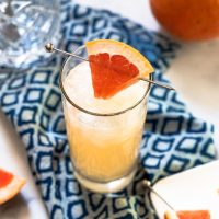 Top-down view of a cocktail garnished with a wedge of fresh grapefruit - Hostess At Heart