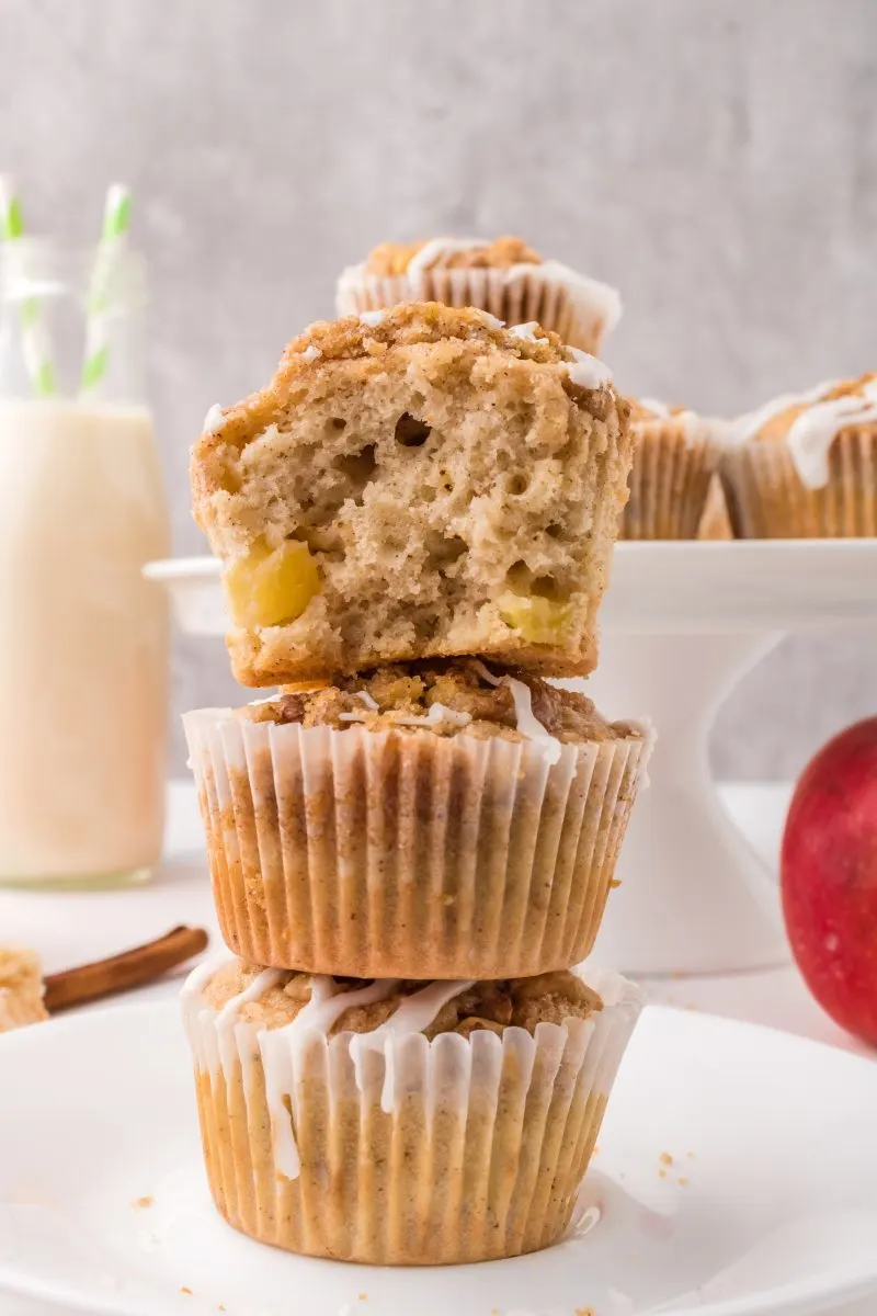 A stack of three glazed muffins with a bite taken out of the top one. Hostess At Heart