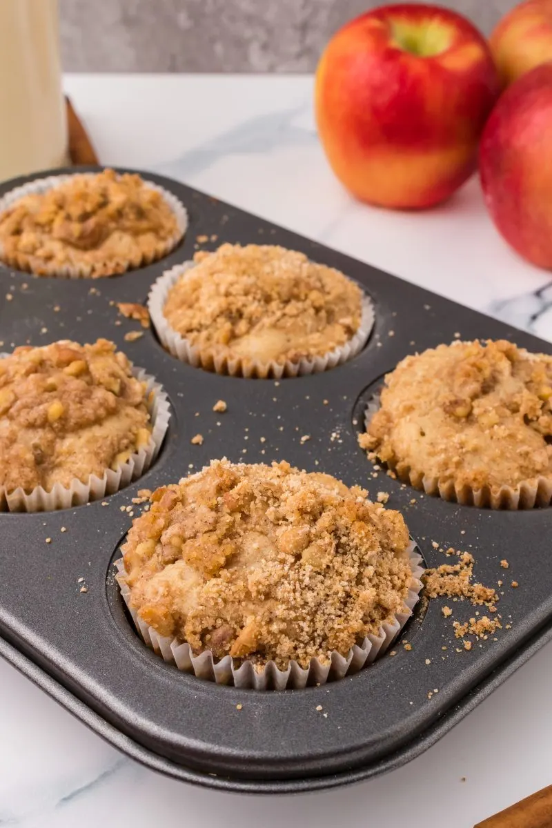 A muffin tin filled with baked Apple Muffins with Crumble Topping - Hostess At Heart