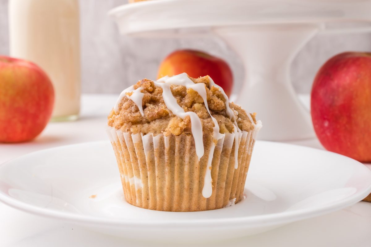 Sideview of an apple muffin topped with crumb Topping and glaze. Hostess At Heart